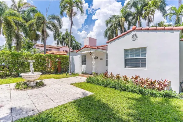 a front view of a house with a yard and potted plants