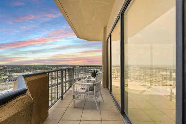 a view of a balcony with chair and floor to ceiling window