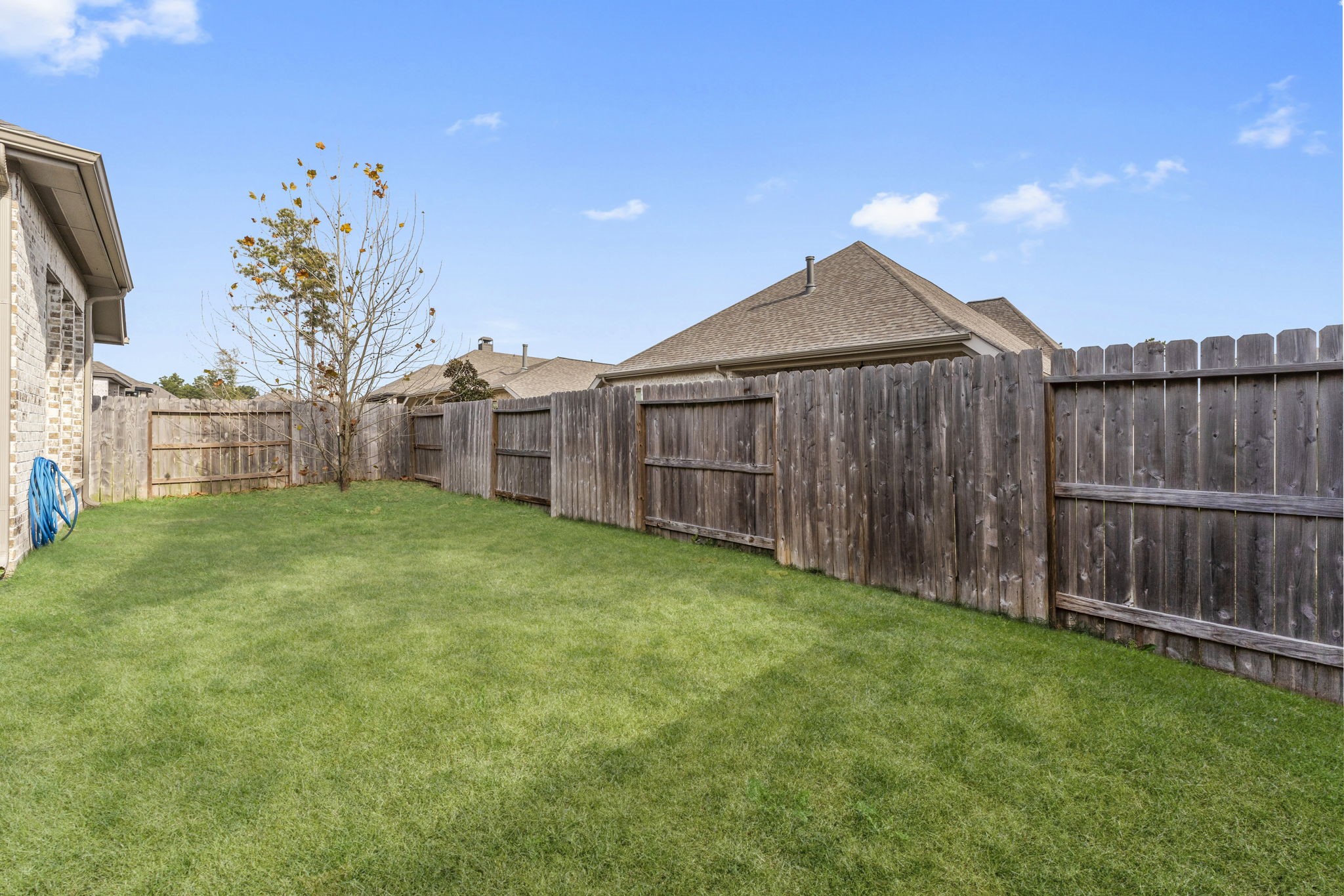 17163 Sandstone Street Conroe, TX 77302 - Photo 27 of 31 a view of a backyard with a plants and wooden fence