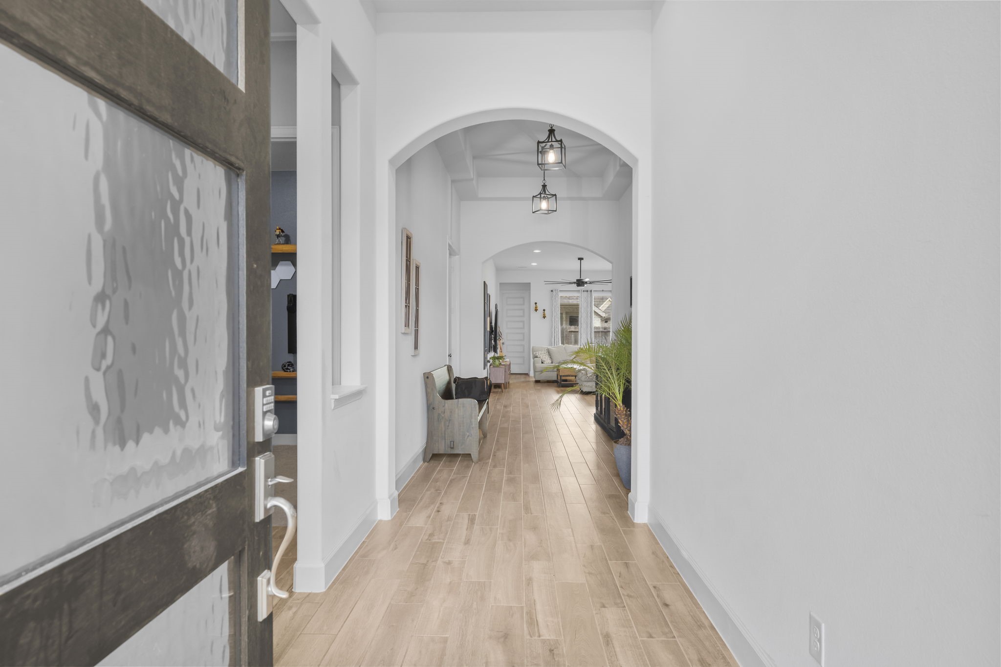 17163 Sandstone Street Conroe, TX 77302 - Photo 3 of 31 a view of a hallway with wooden floor and a living room