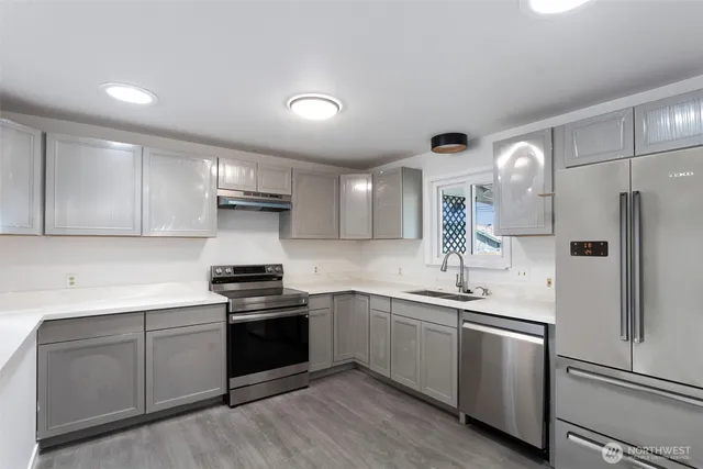 a kitchen with a sink stainless steel appliances and cabinets