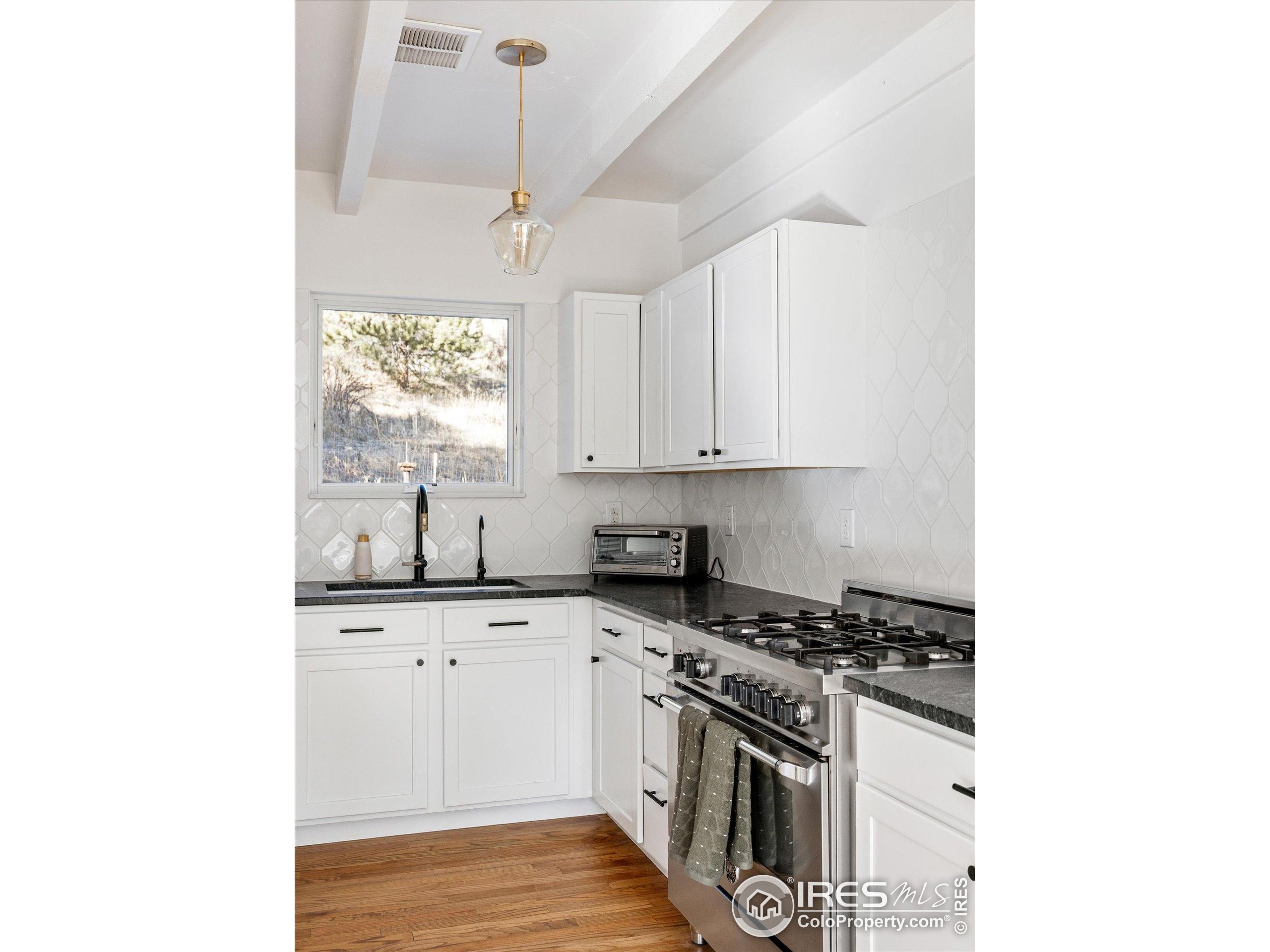 781 Cold Springs Road Boulder, CO 80302 - Photo 11 of 36 a kitchen with granite countertop a sink cabinets stainless steel appliances and a window