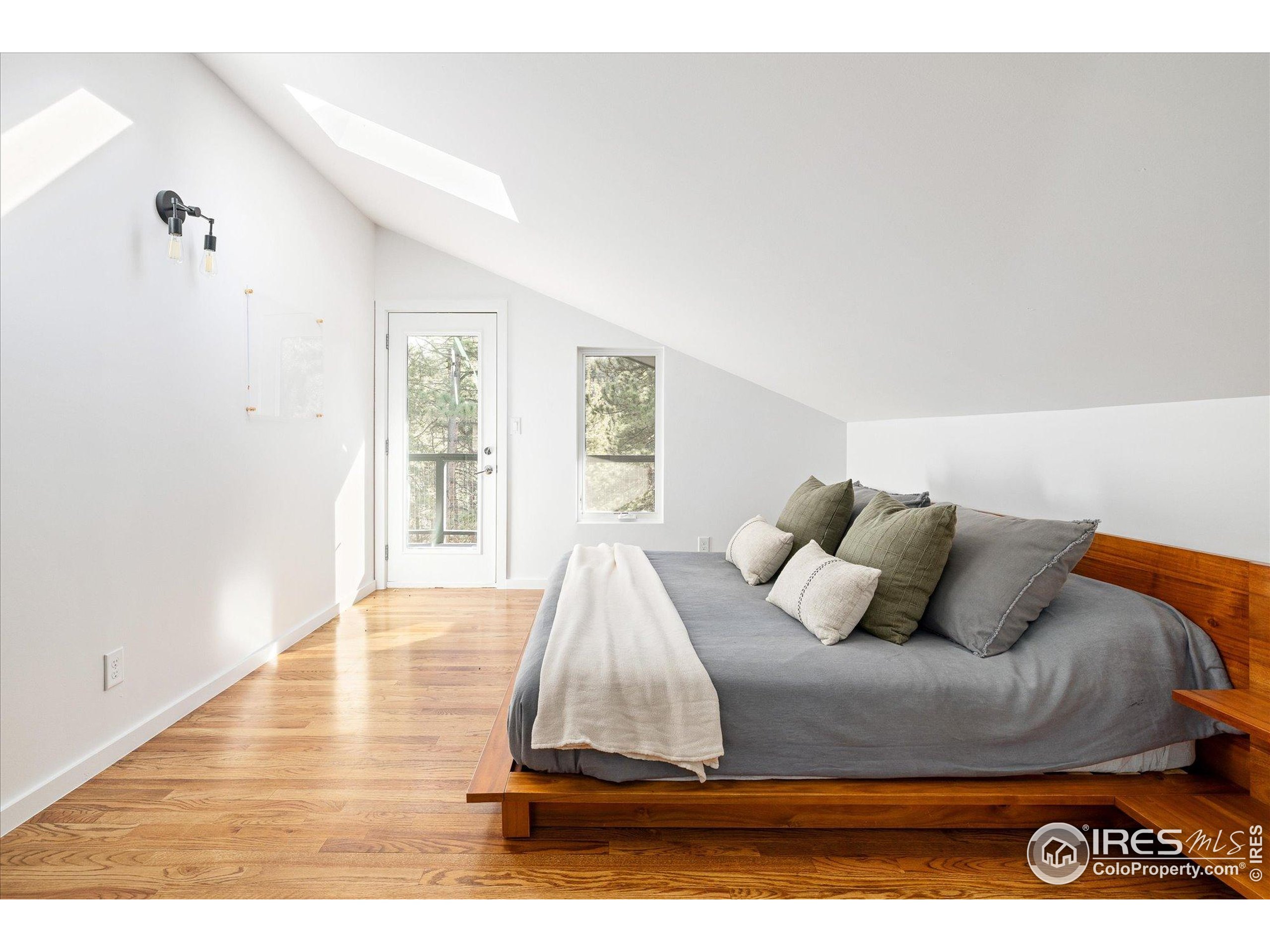 781 Cold Springs Road Boulder, CO 80302 - Photo 12 of 36 a bedroom with a bed and wooden floor