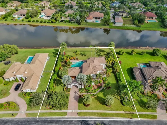 an aerial view of a house with a yard and lake view