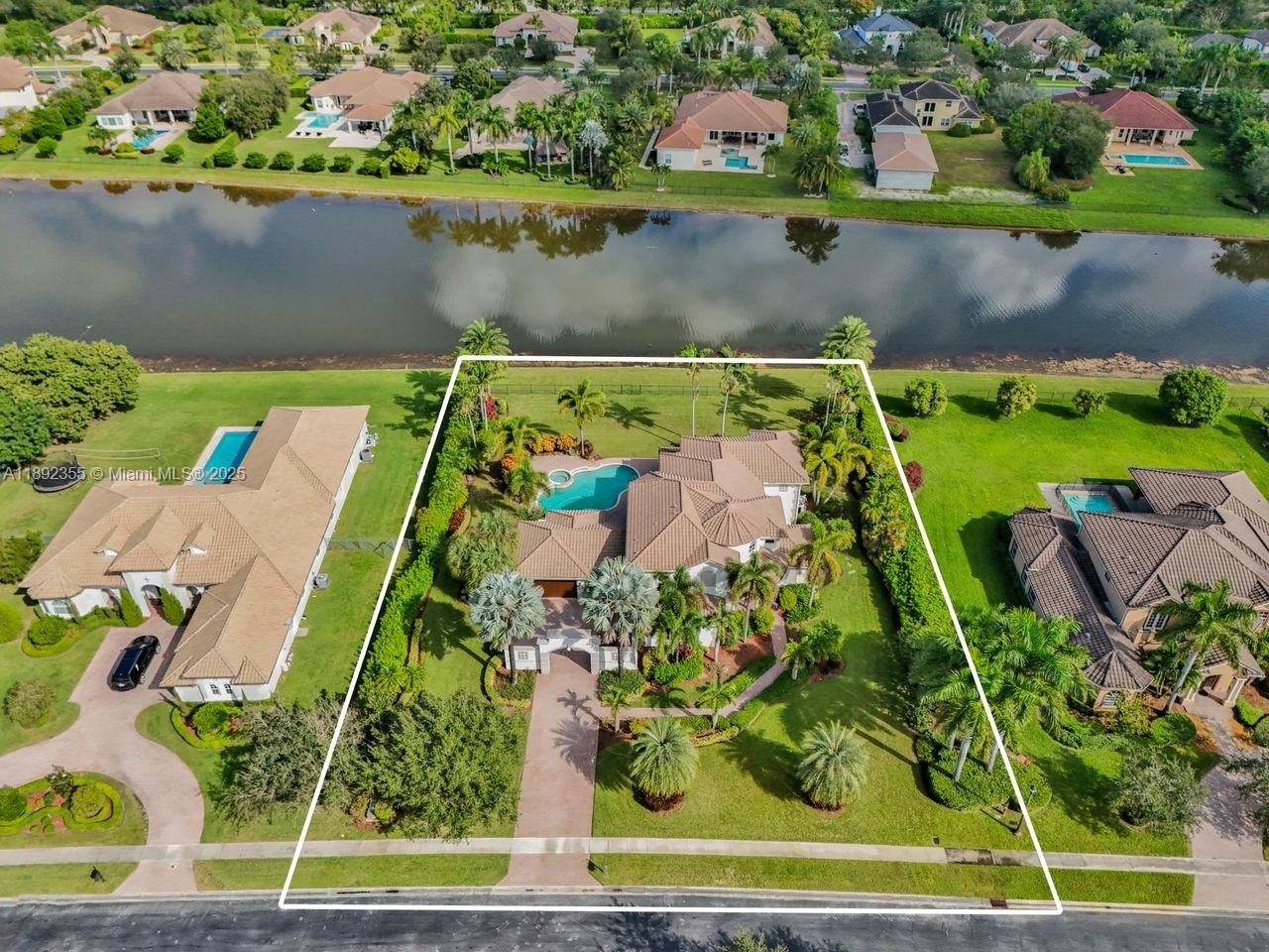 an aerial view of a house with a yard and lake view