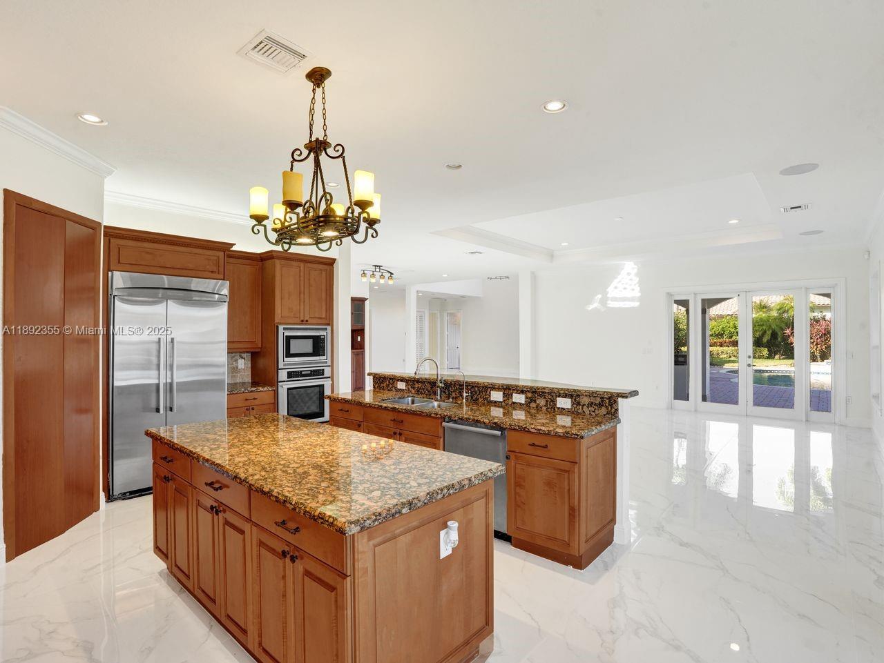 14403 Jockey Circle Davie, FL 33330 - Photo 18 of 53 a kitchen with stainless steel appliances granite countertop a stove and a center island