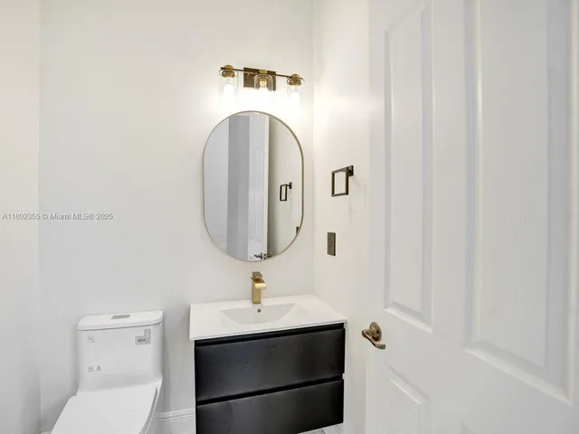 a bathroom with a shower sink vanity mirror and toilet
