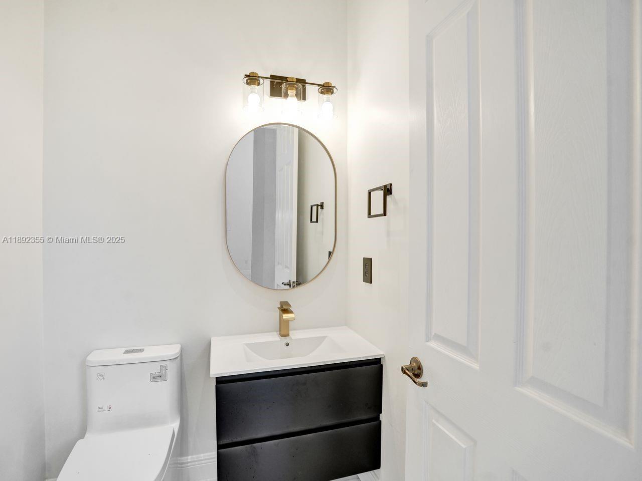 14403 Jockey Circle Davie, FL 33330 - Photo 23 of 53 a bathroom with a sink and mirror with toilet