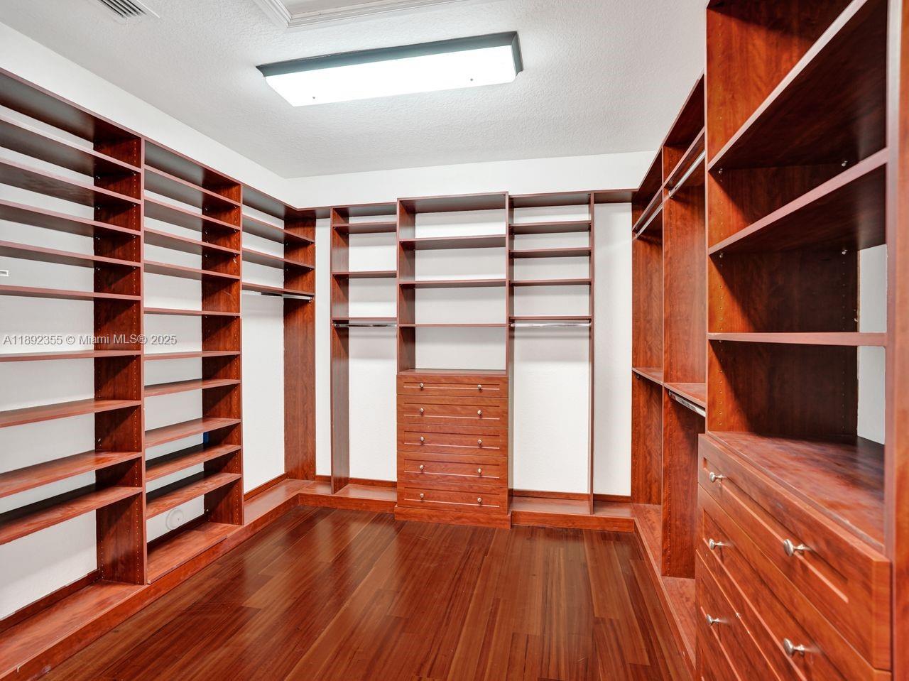 14403 Jockey Circle Davie, FL 33330 - Photo 33 of 53 a view of walk in closet with wooden floor and shoes