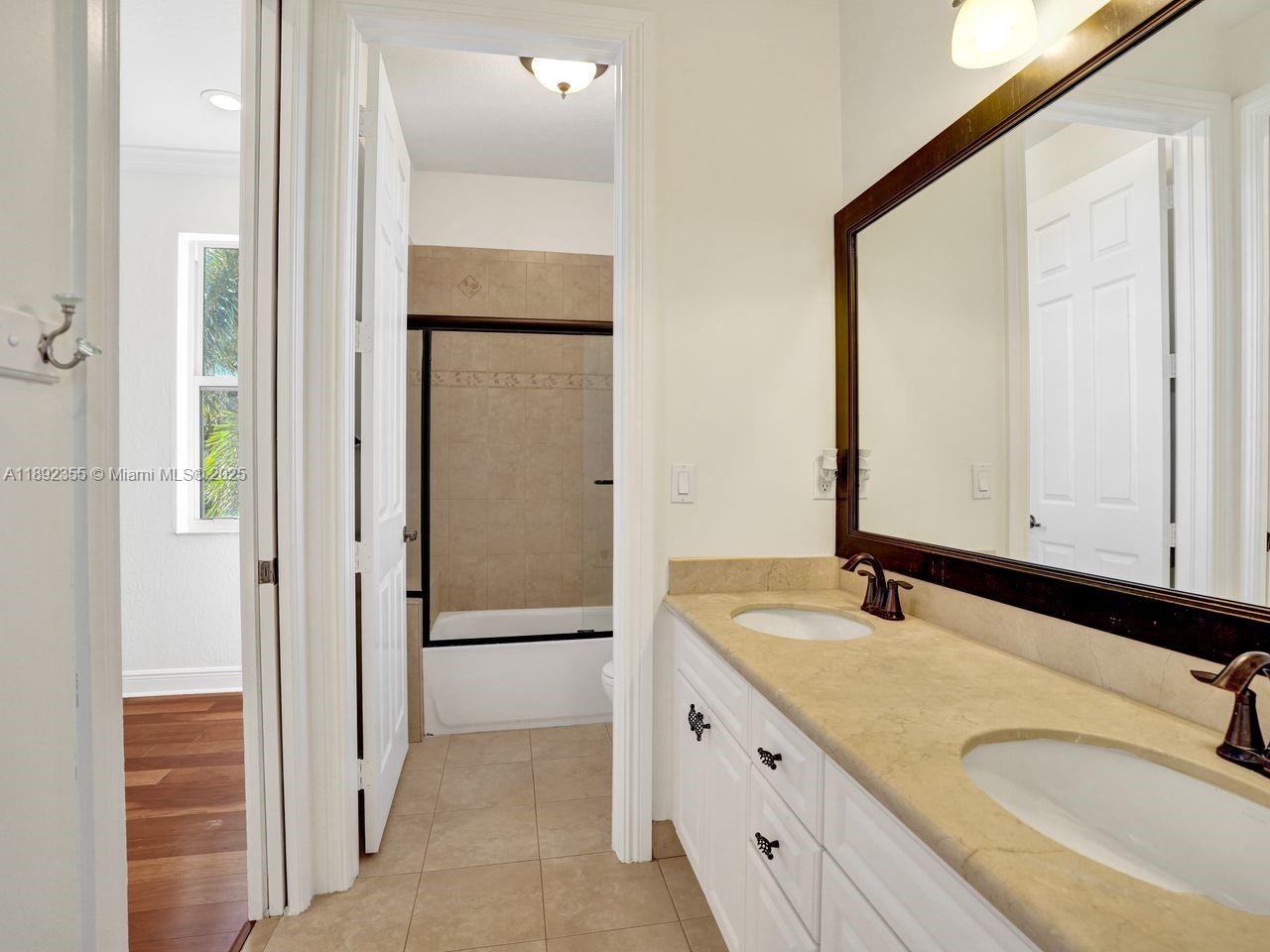 14403 Jockey Circle Davie, FL 33330 - Photo 40 of 53 a bathroom with a granite countertop sink and a mirror