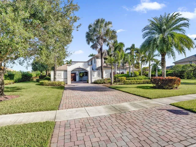 a front view of a house with yard and green space