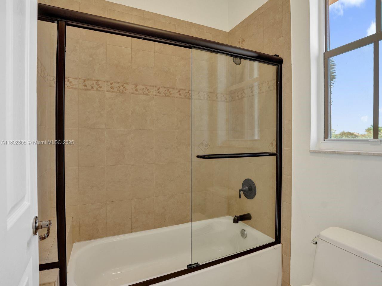 14403 Jockey Circle Davie, FL 33330 - Photo 41 of 53 a bathroom with a glass shower door