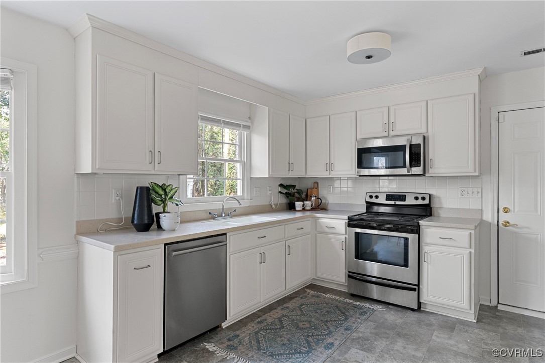 5801 Mill Spring Road Midlothian, VA 23112 - Photo 17 of 49 a kitchen with white cabinets sink and stainless steel appliances