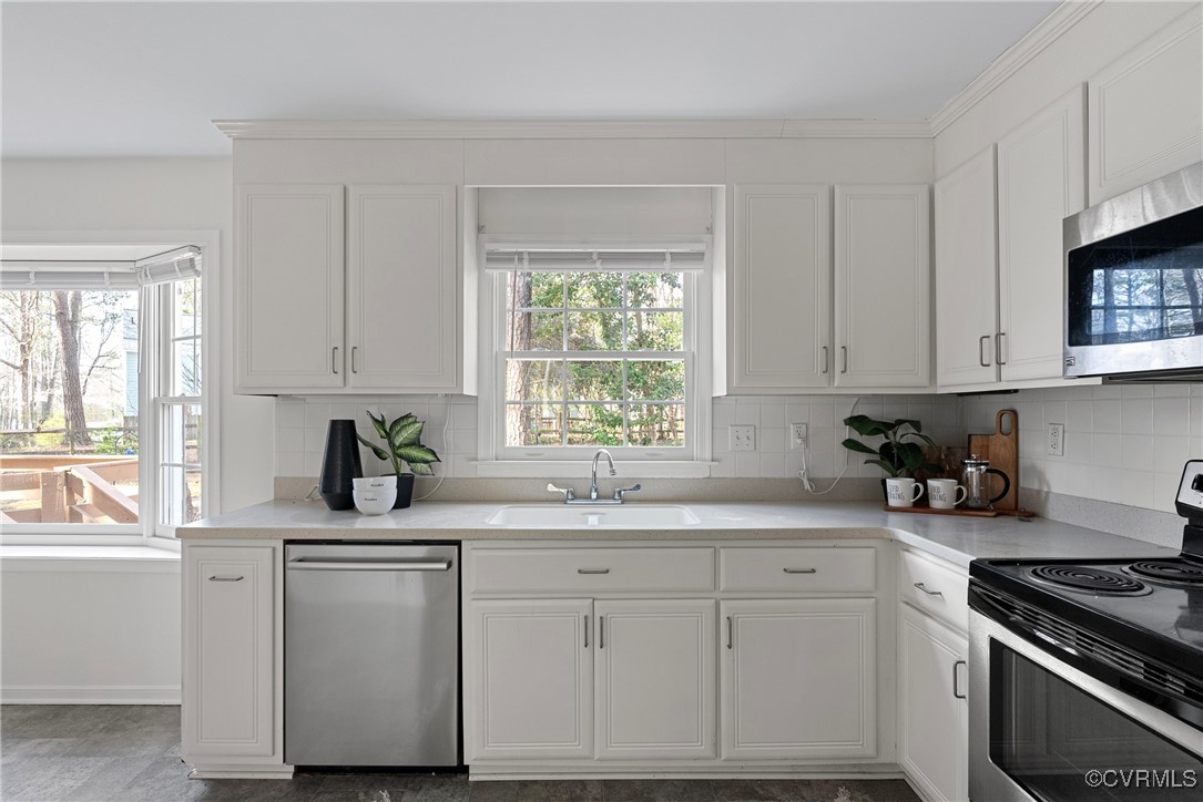 5801 Mill Spring Road Midlothian, VA 23112 - Photo 19 of 49 a kitchen with white cabinets appliances a sink and a window