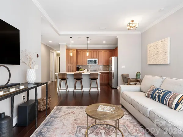 a living room with furniture a flat screen tv and kitchen view