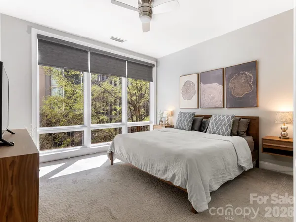 a bedroom with a bed and a large window