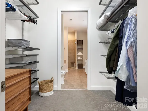 a view of walk in closet with clothes and shoes