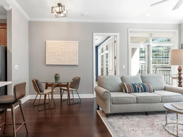 a living room with furniture wooden floor and a large window
