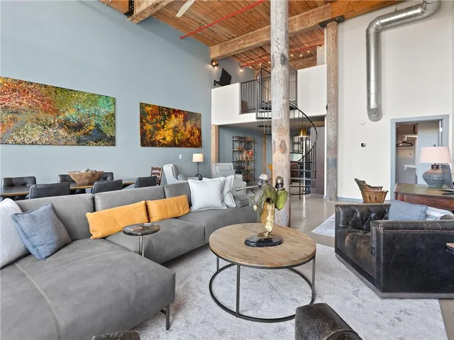 a living room with furniture a rug and white walls