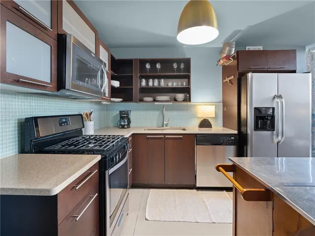 a kitchen with stainless steel appliances granite countertop a sink and a stove