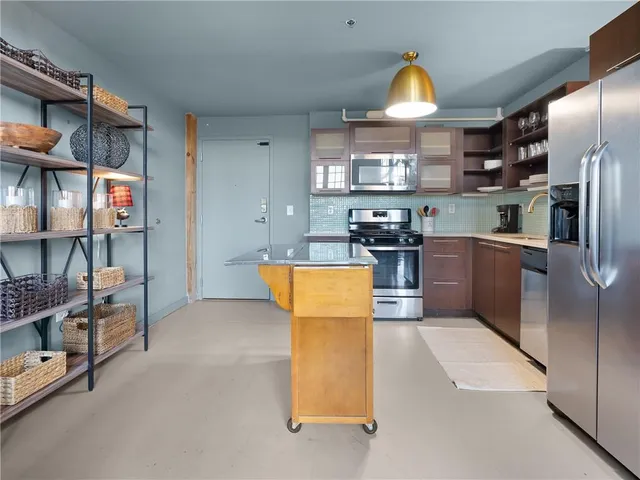 a kitchen with stainless steel appliances granite countertop a refrigerator and a stove