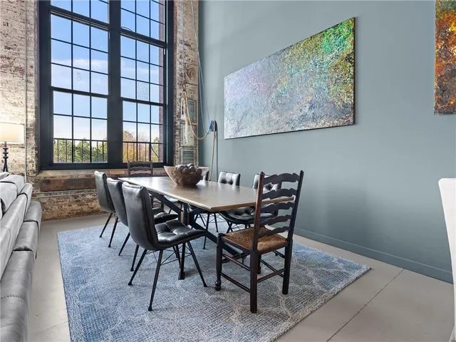 a view of a dining room and livingroom with furniture a rug and wooden floor