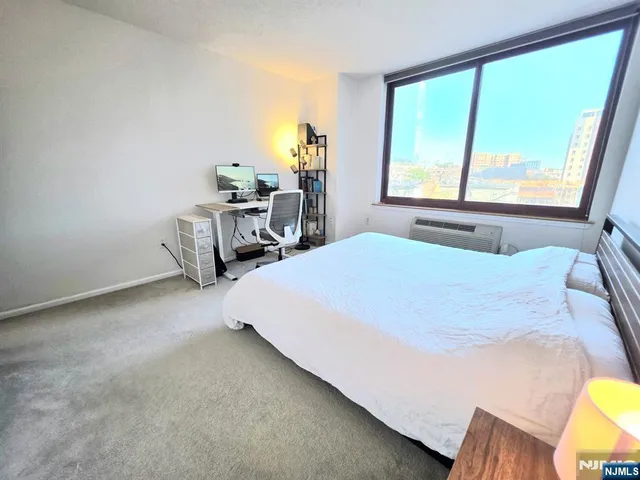 a bedroom with a bed a table and windows