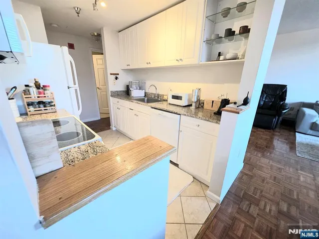 a kitchen with granite countertop a sink stove and refrigerator