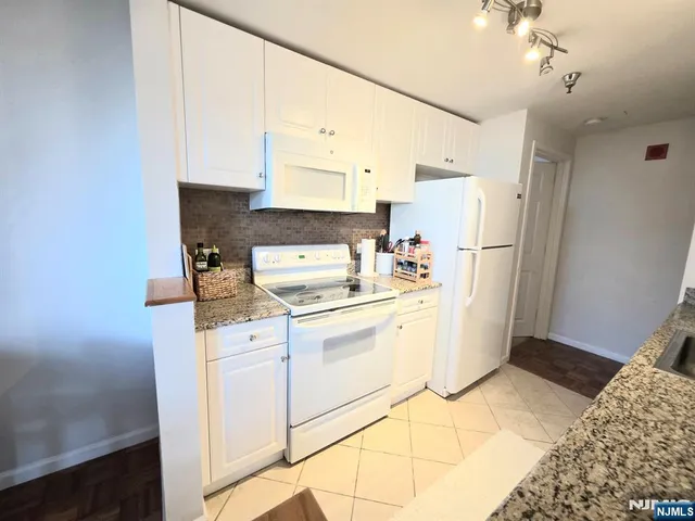 a kitchen with a refrigerator a stove a microwave and cabinets