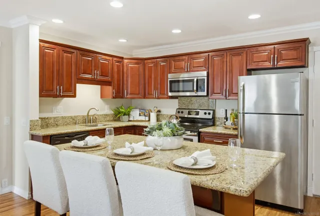 a kitchen with stainless steel appliances granite countertop a sink stove and refrigerator