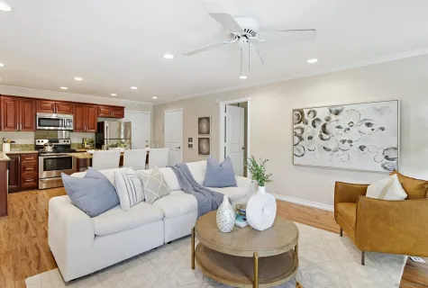 a living room with furniture kitchen and a chandelier
