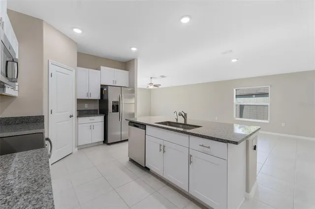 a kitchen with white cabinets and refrigerator
