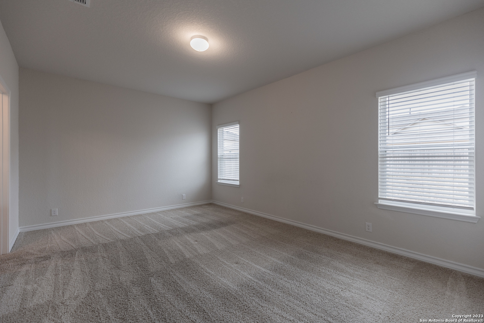 9819 Bratten Rise San Antonio, TX 78254 - Photo 13 of 37 an empty room with wooden floor and windows