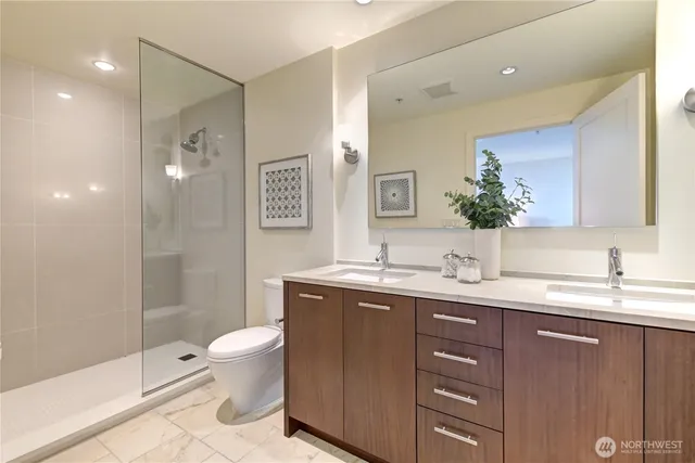 a bathroom with a granite countertop toilet sink and mirror