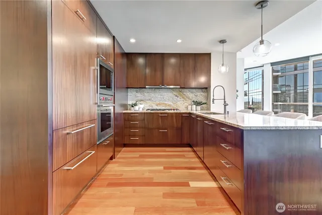 a kitchen with stainless steel appliances granite countertop a sink a stove and a refrigerator