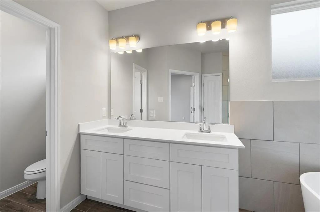332 Stellar Wind Drive Georgetown, TX 78628 - Photo 16 of 29 Double vanity sinks and bright lighting enhance this pristine bathroom retreat.