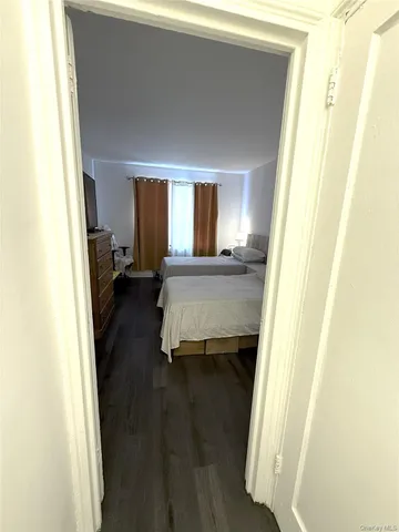 a room with a bed and a dresser next to a window