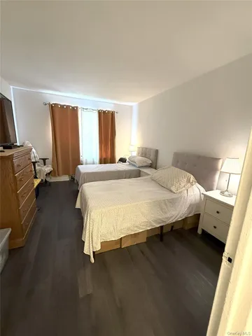 a spacious bedroom with a bed and wooden floor