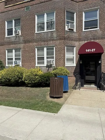 front view of a brick house with a yard