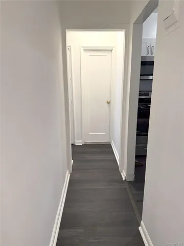 a view of a hallway with wooden floor and entryway