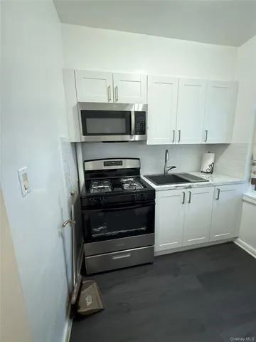 a kitchen with a stove and white cabinets