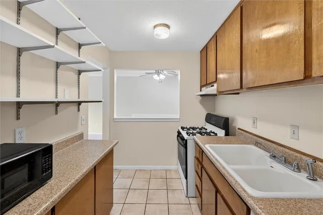 a kitchen with a sink a stove and cabinets