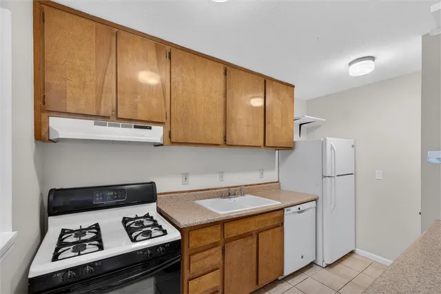 a kitchen with stainless steel appliances granite countertop a stove a refrigerator and a cabinets