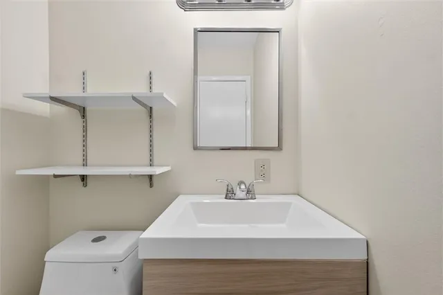 a bathroom with a sink a toilet and a mirror