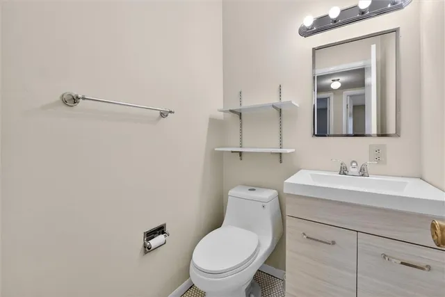a bathroom with a toilet sink vanity and mirror