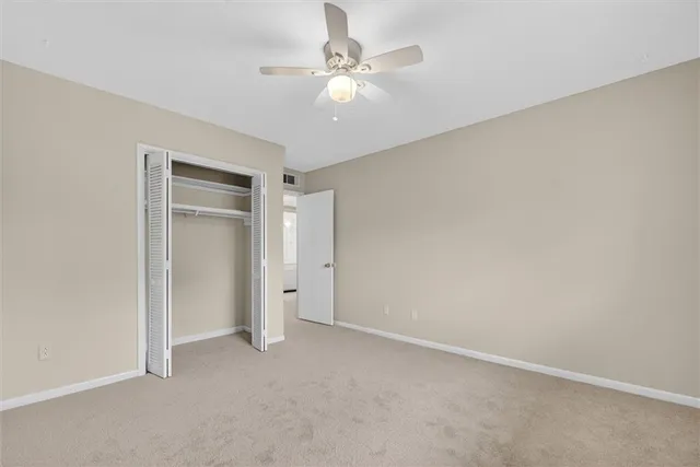 an empty room with a ceiling fan and a window