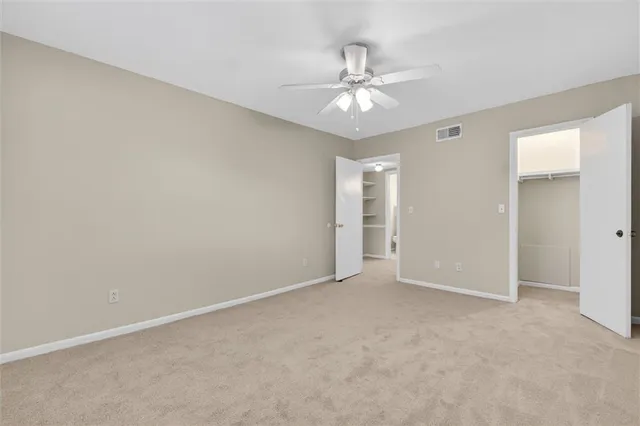 a view of an empty room with a chandelier fan