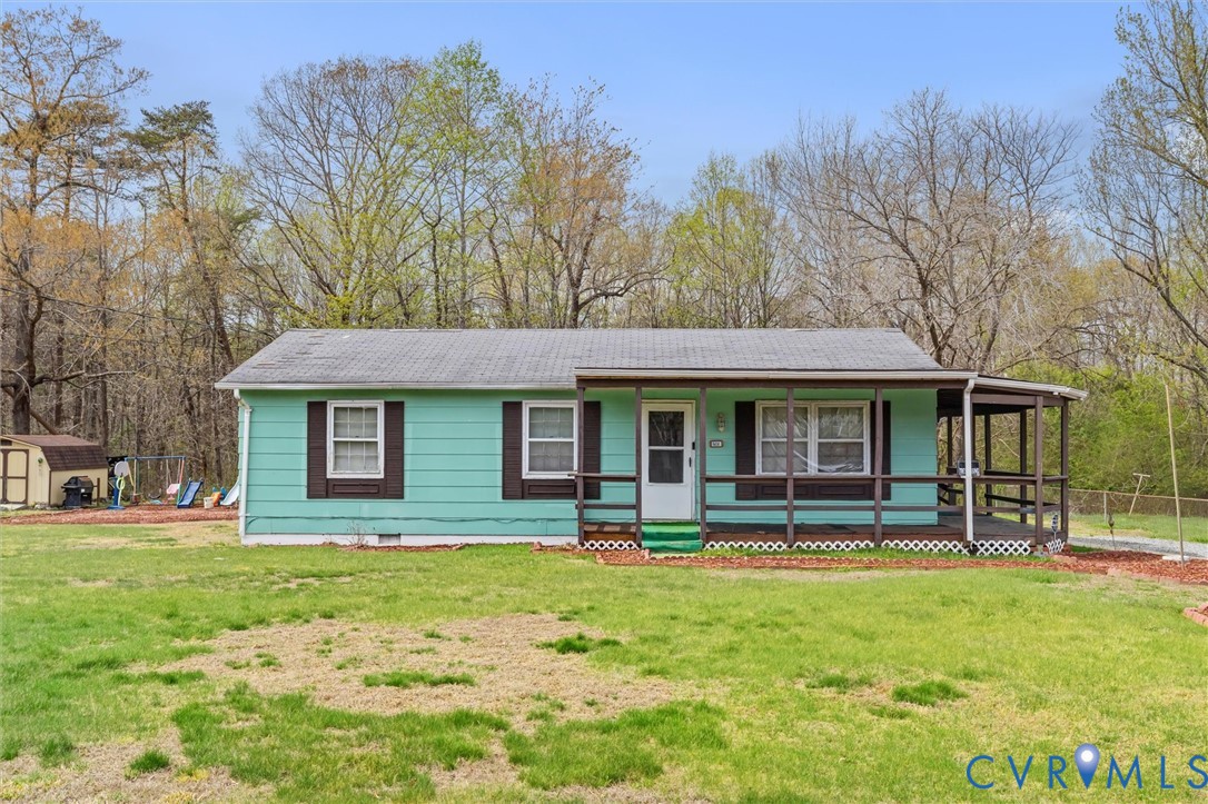 Single story home featuring a porch, a front lawn,