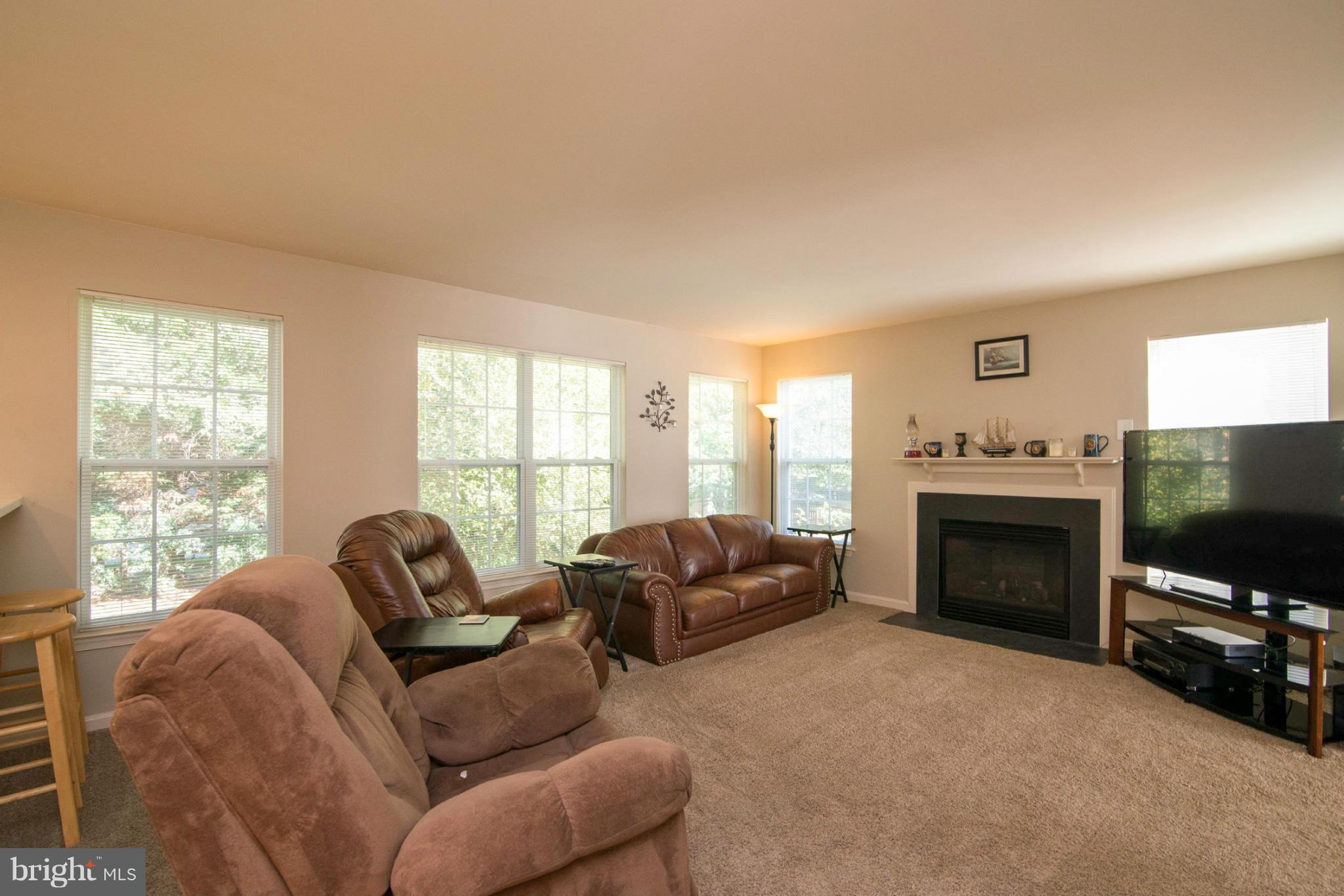 3044 Shoreline Boulevard Laurel, MD 20724 - Photo 3 of 13 a living room with furniture a flat screen tv and a fireplace