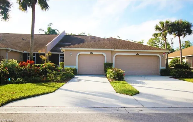 front view of a house with a yard and potted plants